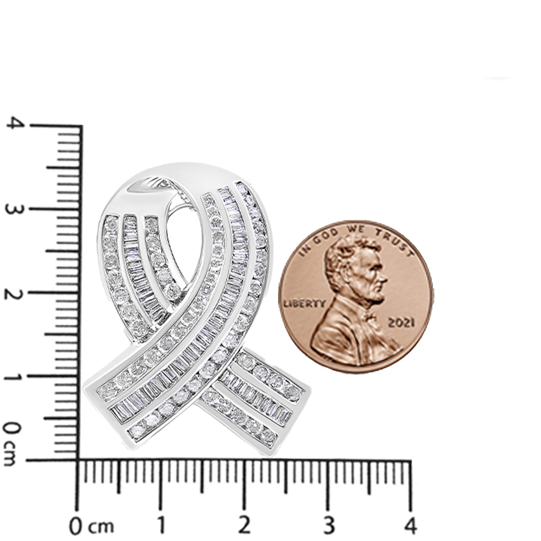 Close-up front angle of a white metal necklace pendant shaped like a ribbon, adorned with channel-set round and baguette white gemstones, displayed on a ruler and next to a penny for size reference.