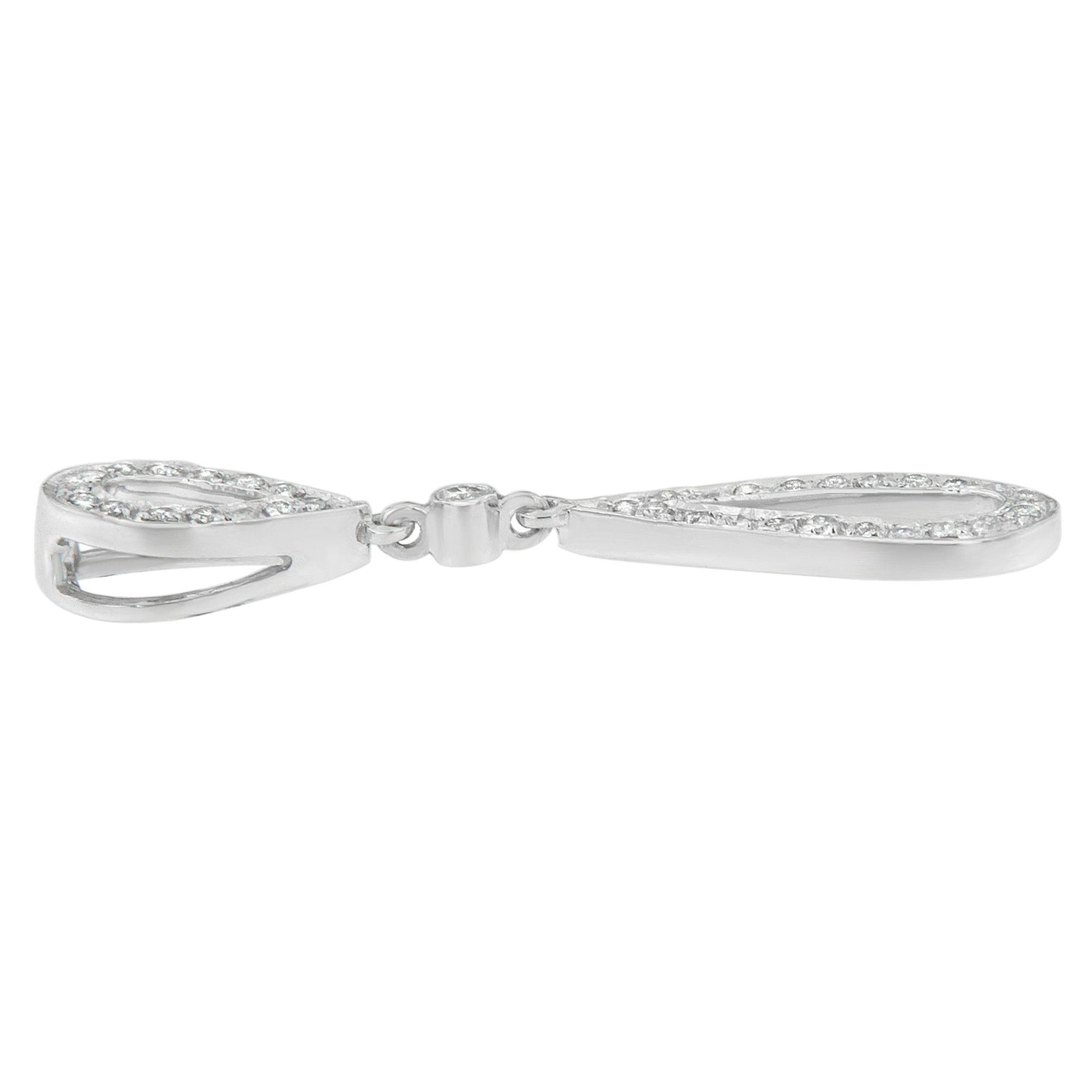 Side view of a white metal necklace with two elongated teardrop shapes, each outlined with round white gemstones in prong settings, connected by a small circular clasp.