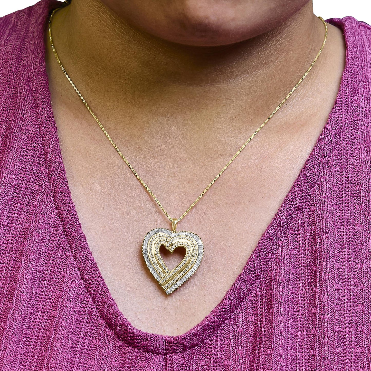 Close-up front view of a yellow metal heart-shaped pendant necklace worn on a model, featuring white round prong-set gemstones and white baguette channel-set gemstones.