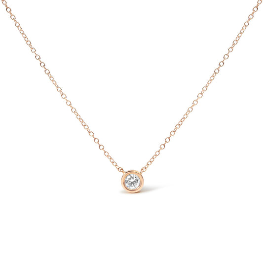 Close-up front view of a rose metal necklace with a single round white gemstone in a bezel setting.