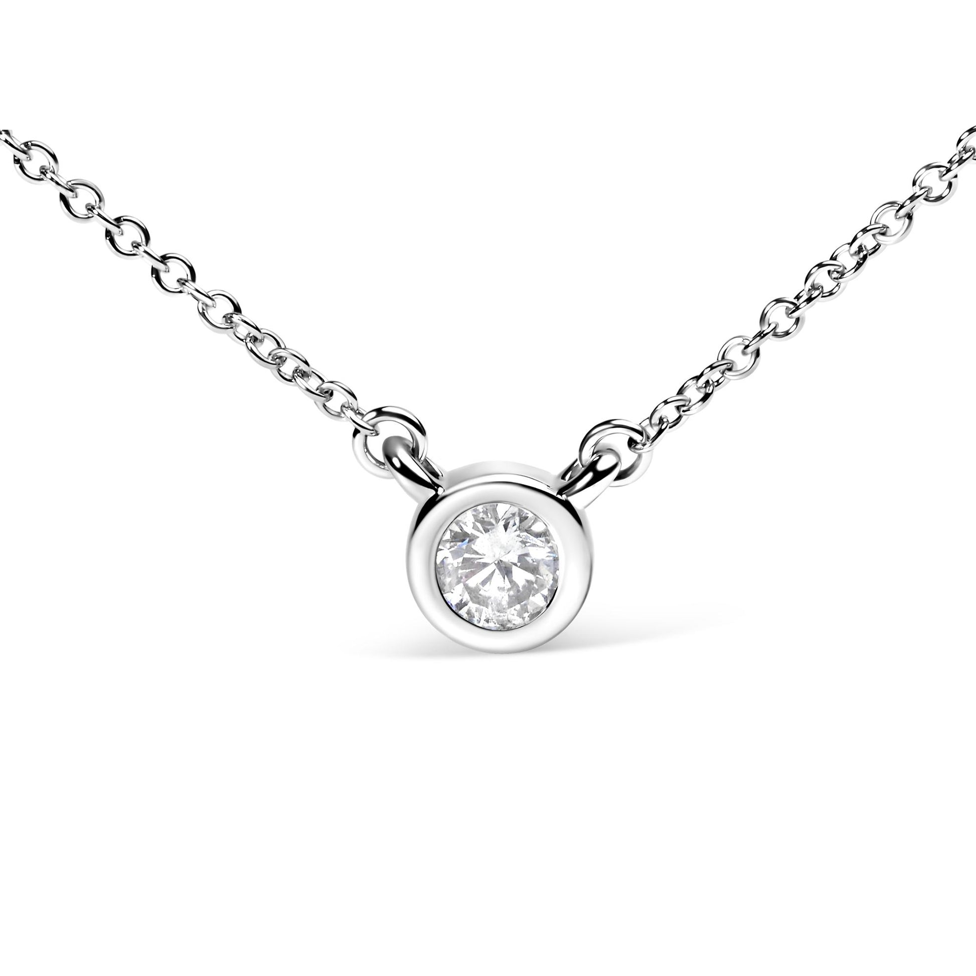 Close-up front view of a white metal necklace with a round bezel-set white gemstone pendant.