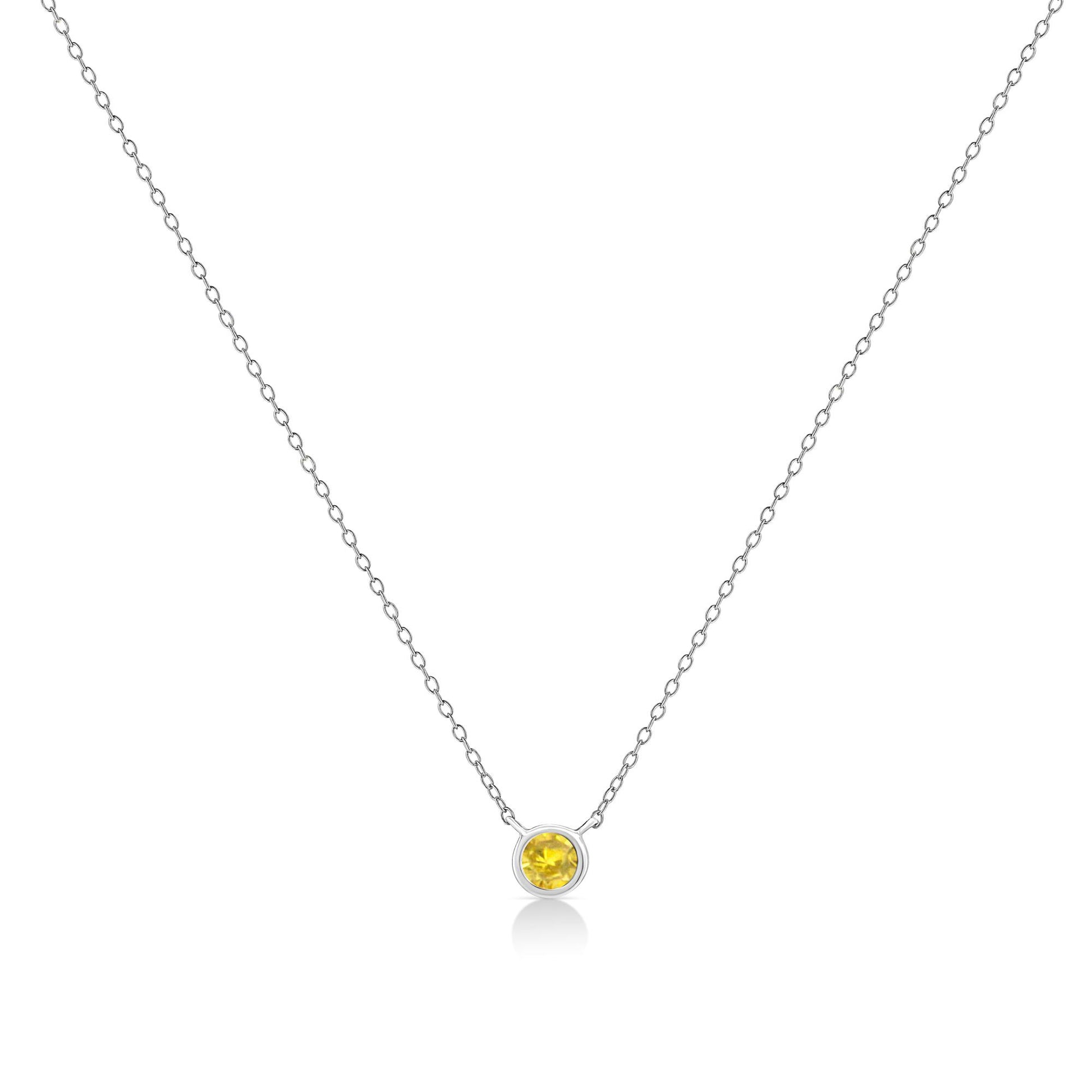 Front view of a white metal necklace with a round yellow gemstone in a bezel setting pendant.
