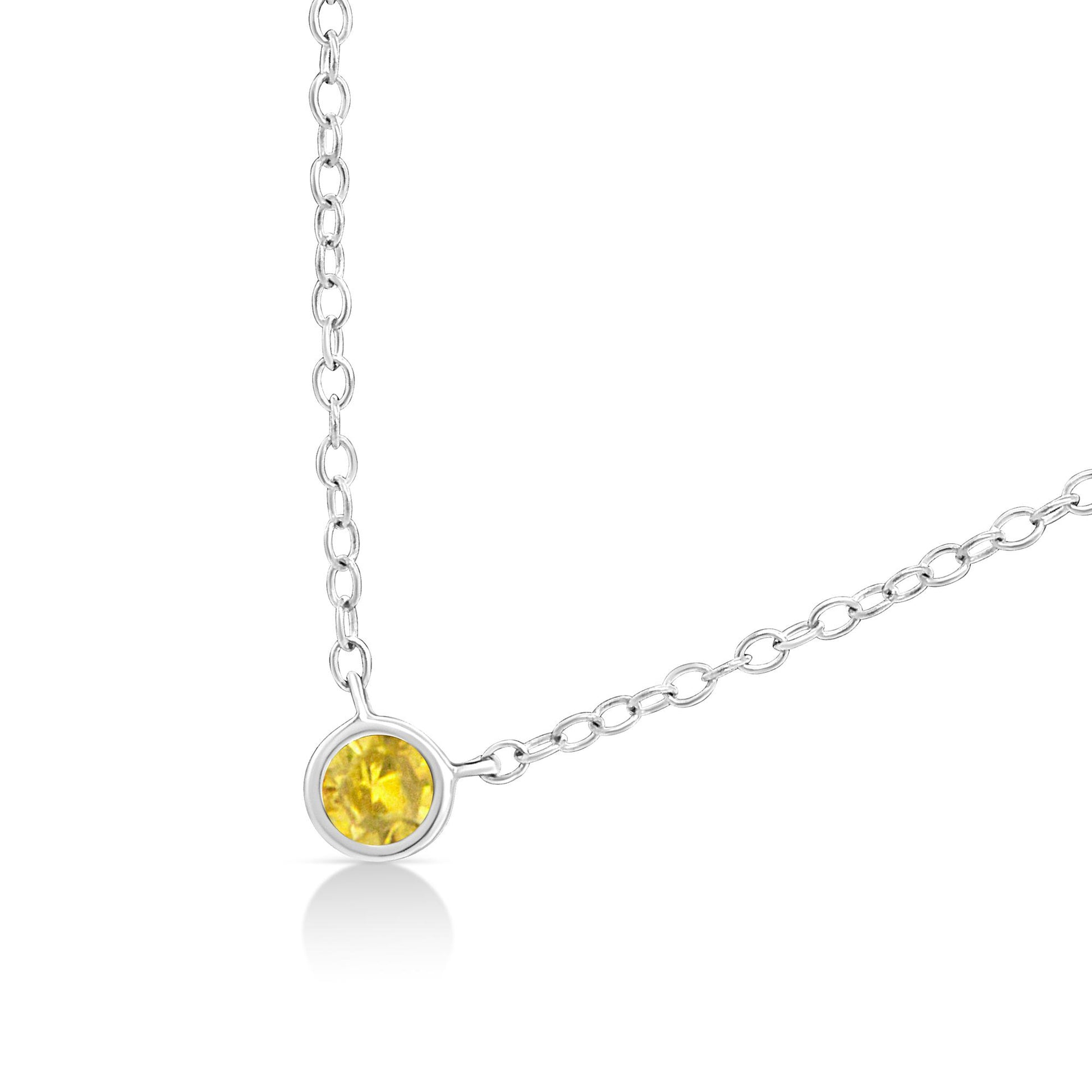 Close-up angled view of a white metal necklace featuring a round yellow bezel-set gemstone pendant.