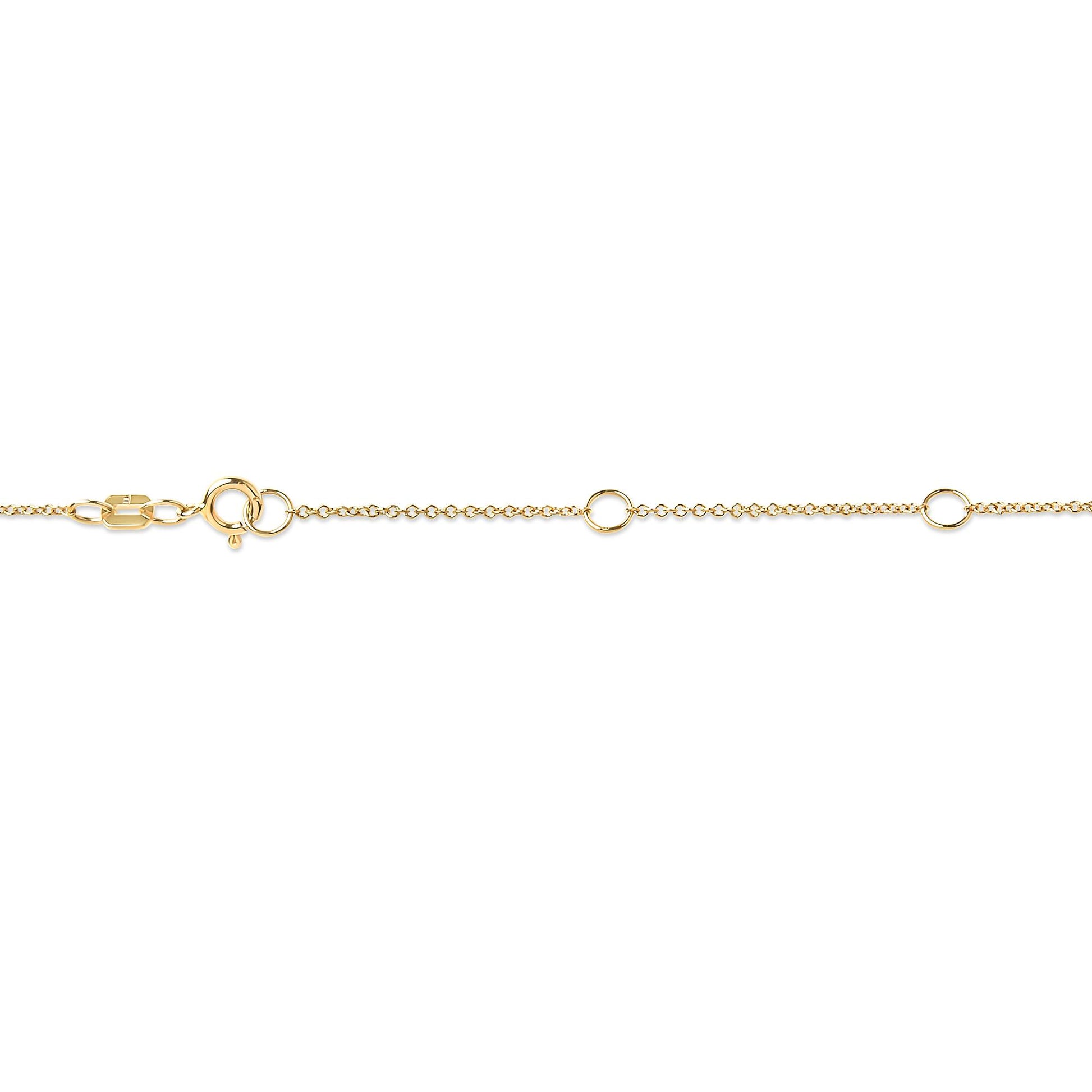 Close-up side angle of a yellow metal necklace chain featuring a round bezel-set white gemstone near the clasp.