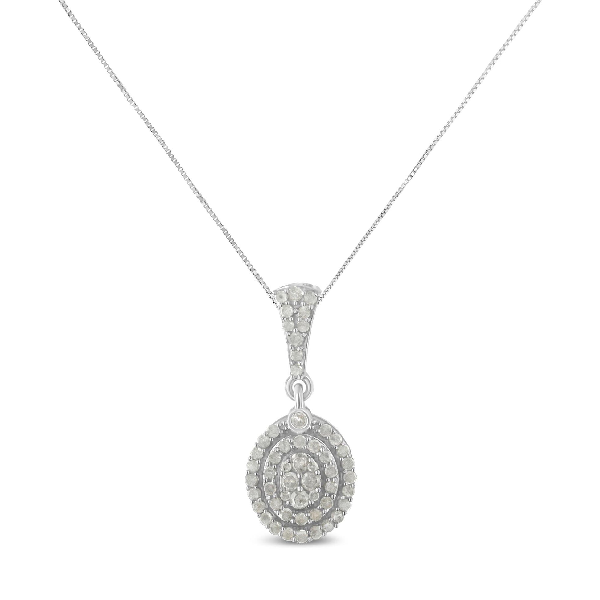 Front-facing shot of a white metal necklace with an oval pendant adorned with multiple round white gemstones in prong settings.