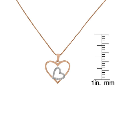 Front view of a yellow and white metal heart-shaped necklace with a smaller heart accented by white gemstones, displayed next to a ruler for size reference.