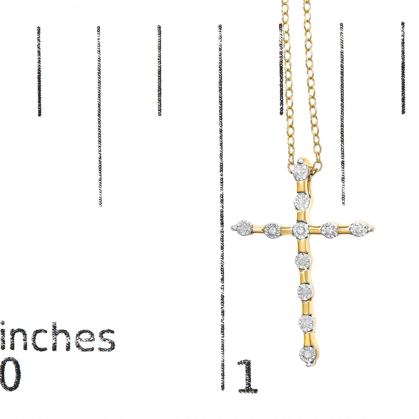 Yellow metal cross-shaped necklace with round white gemstones in miracle setting, shown hanging on a ruler for size reference.