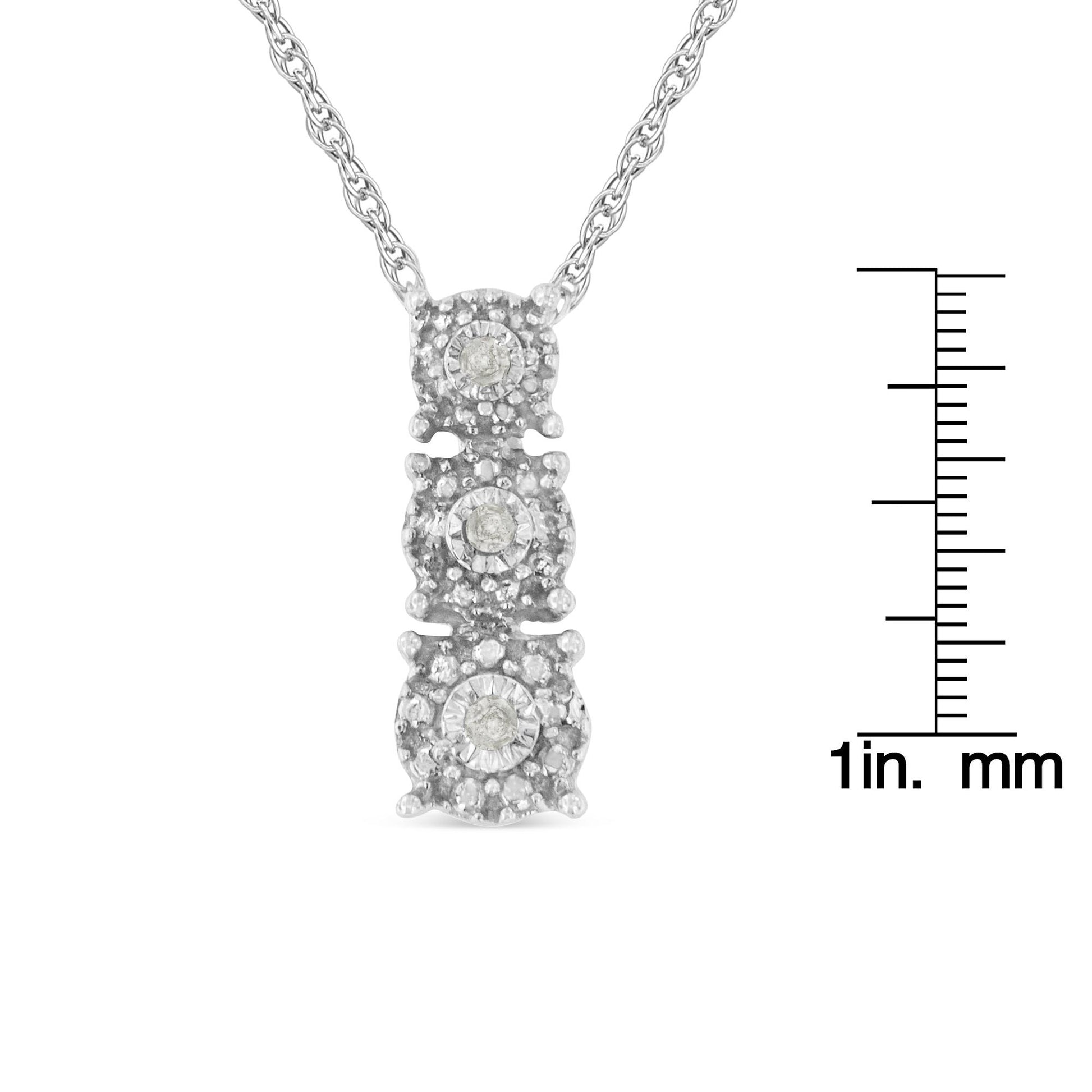 Close-up front view of a white metal necklace pendant featuring three round white gemstones in a vertical arrangement with smaller accent gemstones, shown with a ruler for size reference.