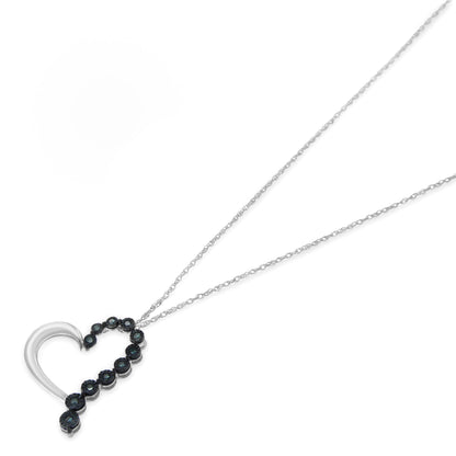 White metal necklace with a heart-shaped pendant featuring round blue gemstones in a miracle setting, shown from a slightly angled top view.