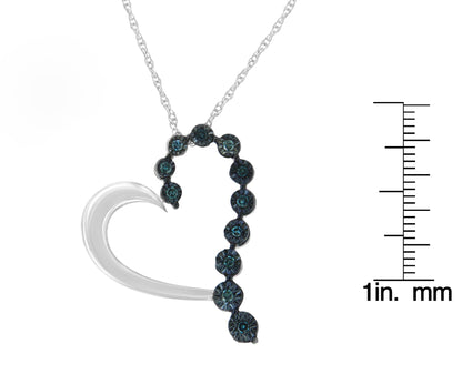 Pendant necklace with a white metal heart outline accented by blue round gemstones in a miracle setting, shown from the front with a ruler for size reference.