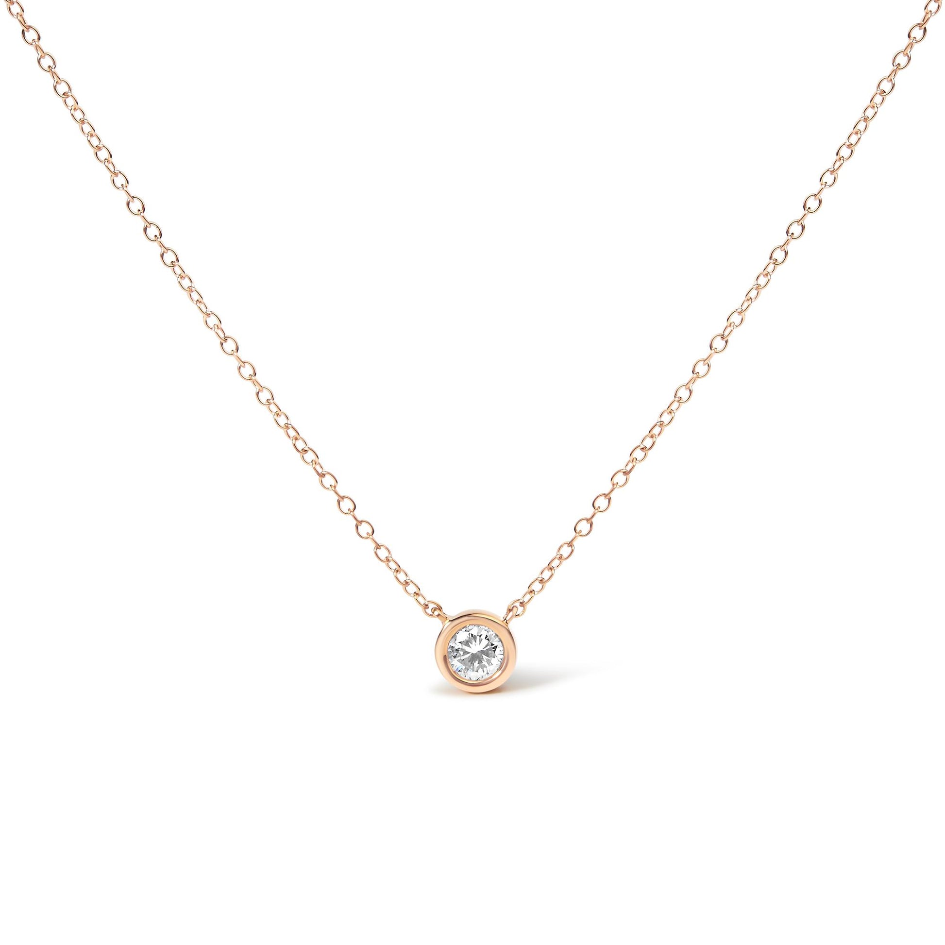 Front view of a rose-colored necklace with a single round white gemstone in a bezel setting pendant.