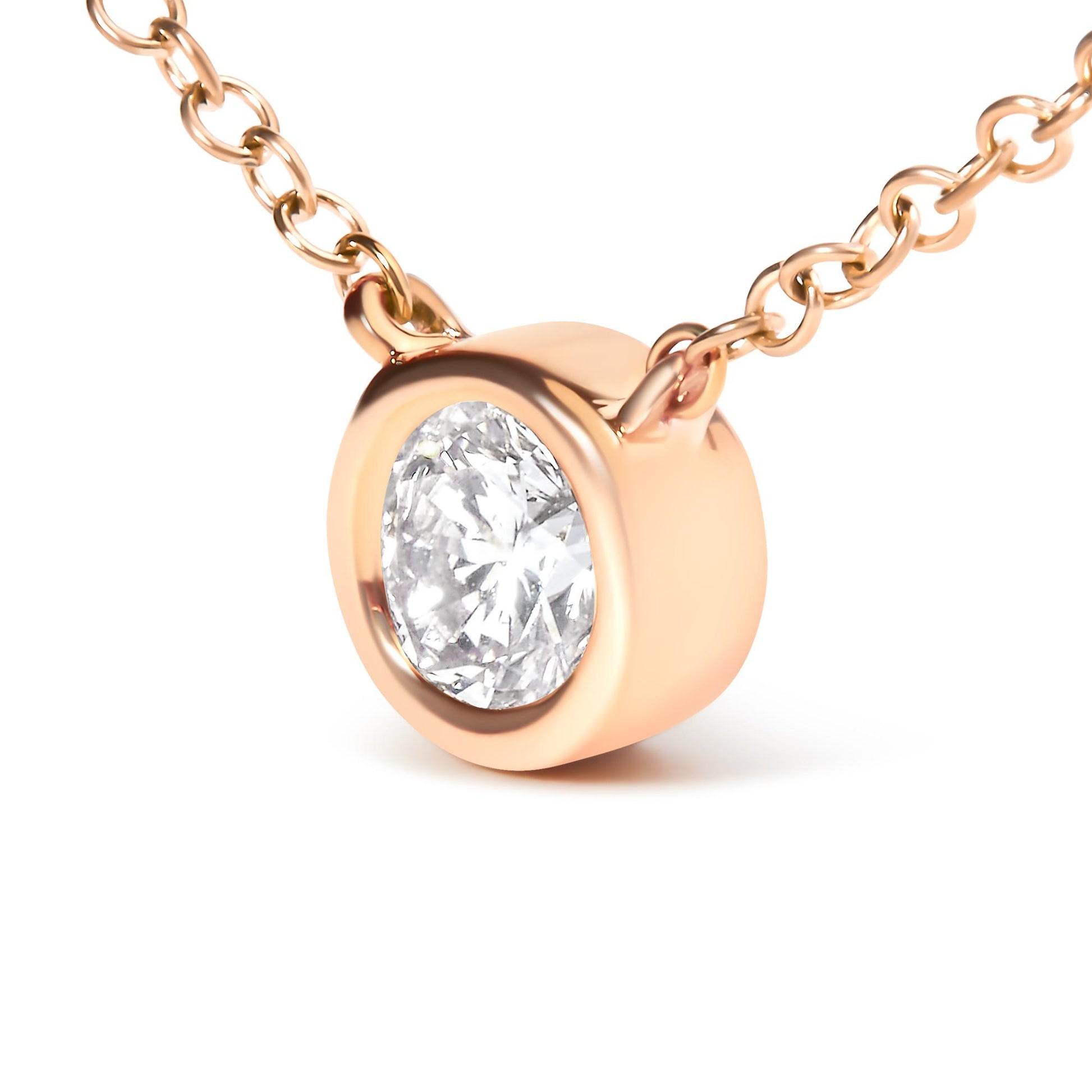 Close-up angled view of a rose-colored necklace with a round white gemstone in a bezel setting.