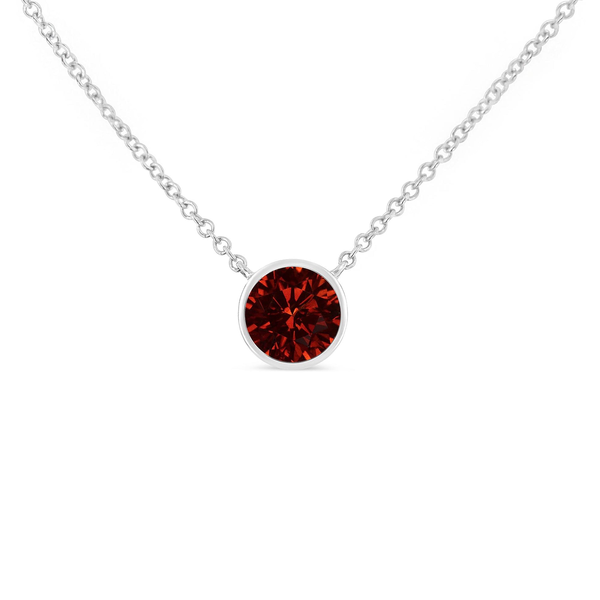 Front view of a white metal necklace with a round red gemstone in a bezel setting.