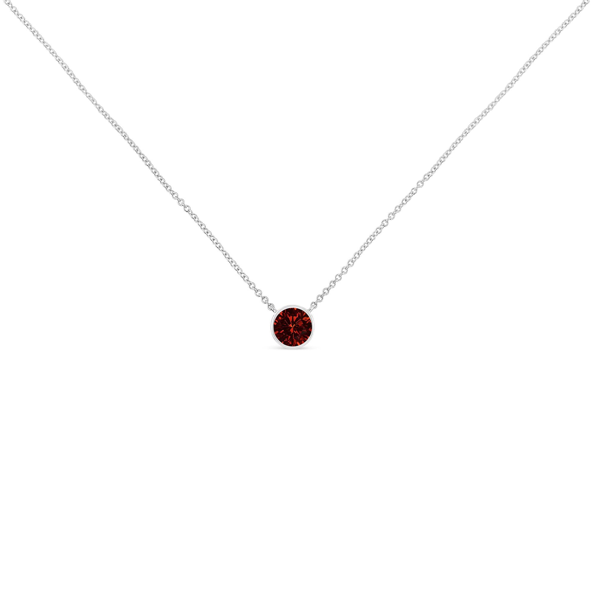Front-facing view of a necklace with a white metal chain and a single round red gemstone in a bezel setting.