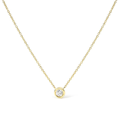 Front-facing close-up of a yellow metal necklace with a single round white gemstone in bezel setting pendant.