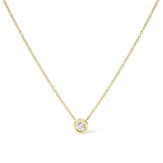 Front-facing close-up of a yellow metal necklace with a single round white gemstone in bezel setting pendant.