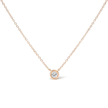 Front-facing view of a rose-colored necklace with a single round white gemstone in a bezel setting.