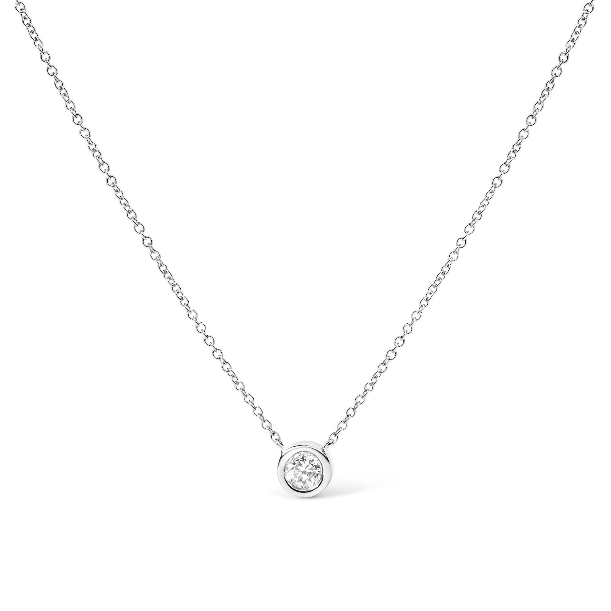 Front-facing shot of a white metal necklace with a round white gemstone in a bezel setting pendant.