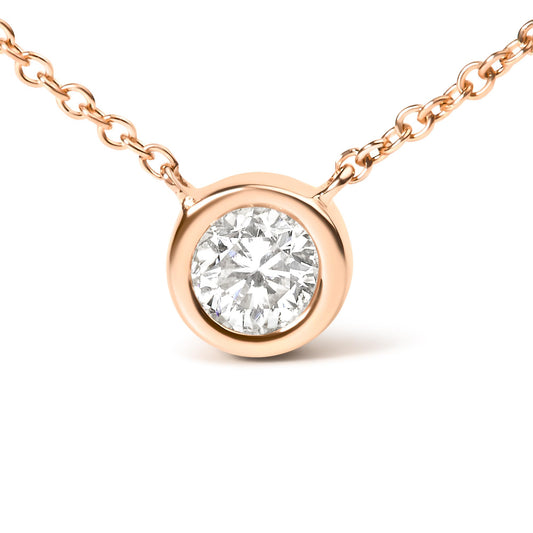 Close-up front view of a rose metal necklace with a round white gemstone in a bezel setting.