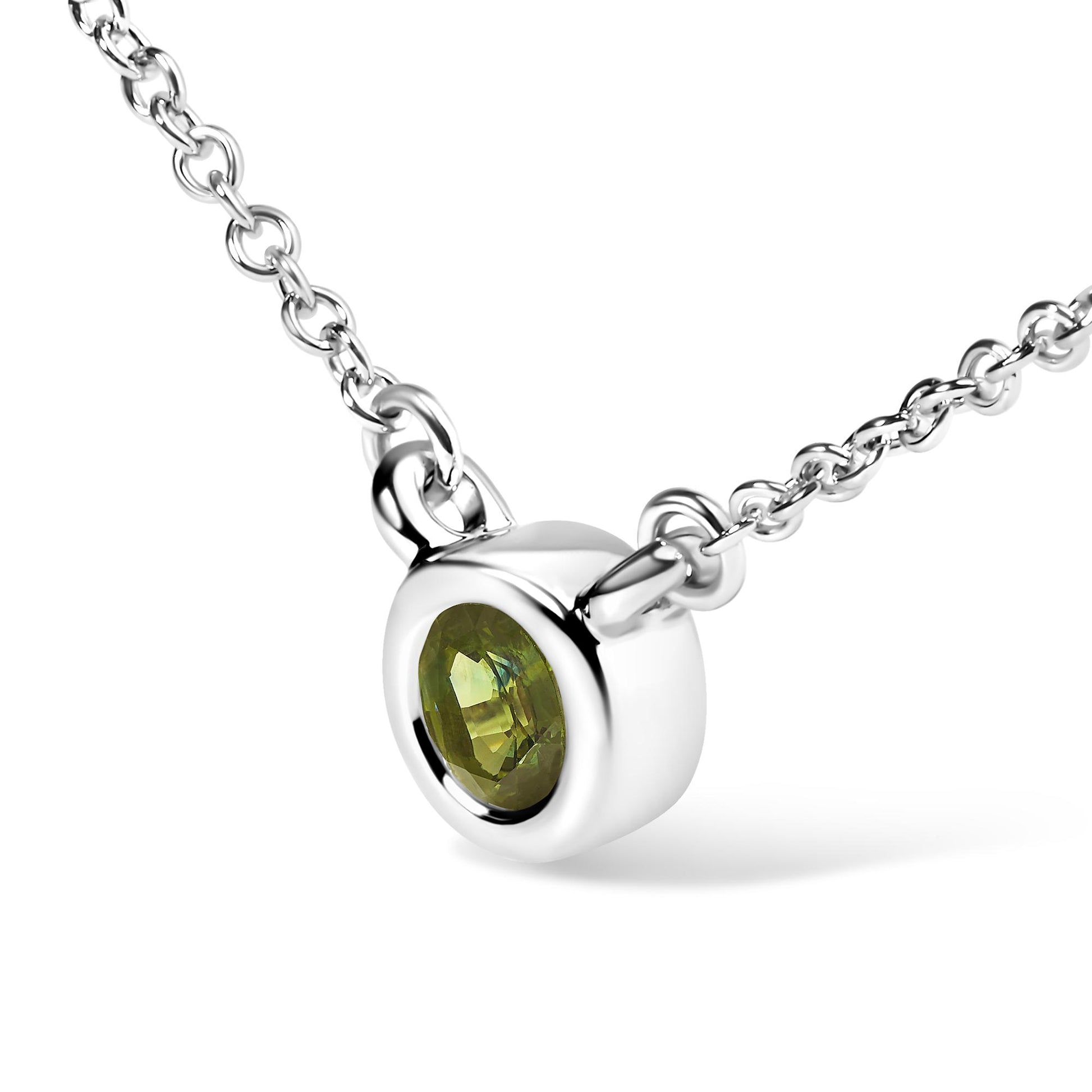 Close-up angled view of a white metal necklace with a round green gemstone in a bezel setting.