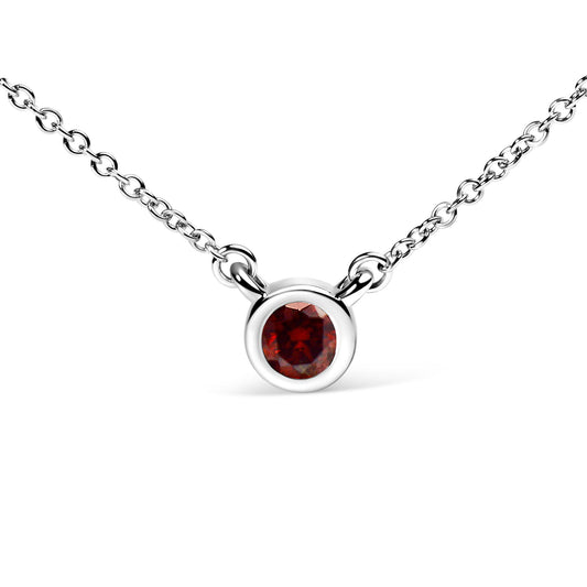 Close-up front view of a white metal necklace with a round red gemstone in a bezel setting.