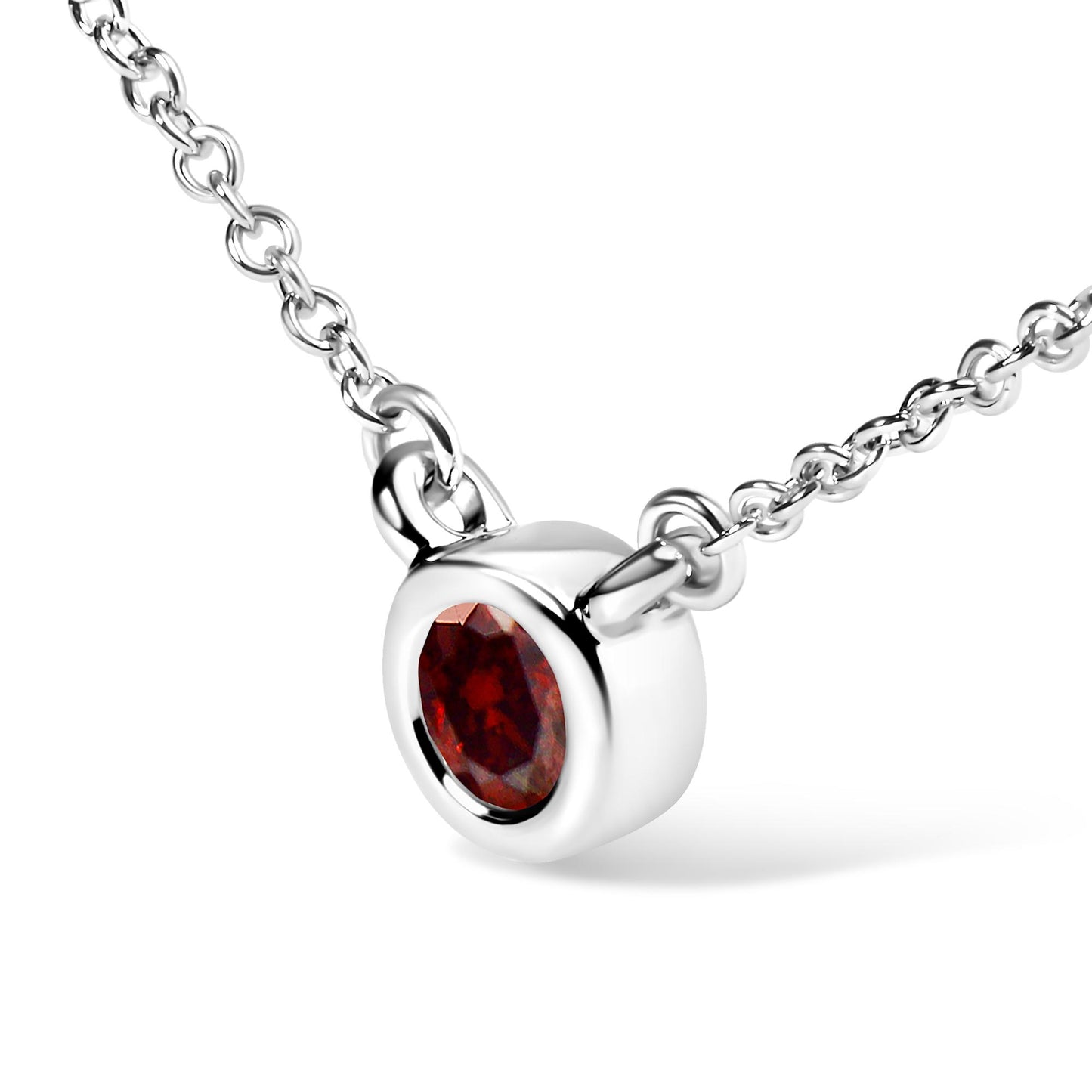 Close-up angled view of a white metal necklace with a round bezel-set red gemstone pendant.