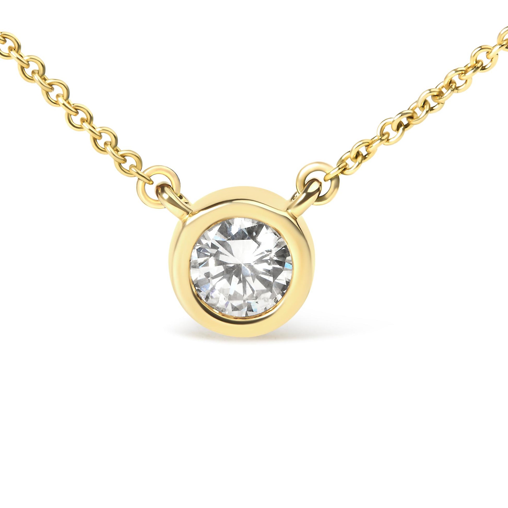 Close-up front view of a yellow metal necklace with a round white gemstone in a bezel setting.