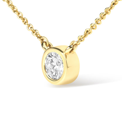Close-up front angle of a yellow metal necklace with a single round white gemstone in a bezel setting.