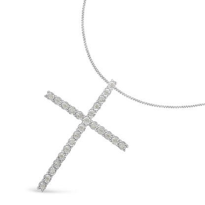 White metal cross-shaped necklace pendant with round white gemstones in a miracle setting, displayed at an angled top-down view.
