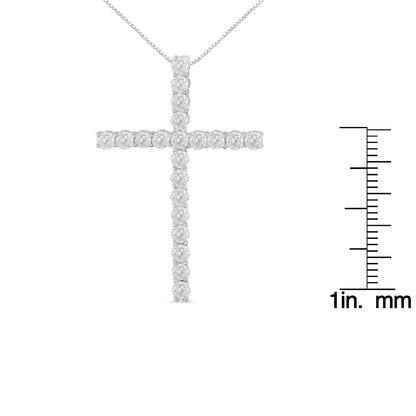 Front-facing image of a white necklace cross pendant with round white gemstones in prong settings, shown next to a ruler for size reference.