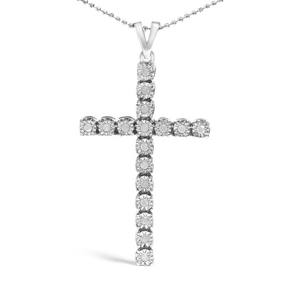 Front-facing shot of a white metal cross-shaped necklace pendant featuring round white gemstones in a miracle setting on a ball chain.
