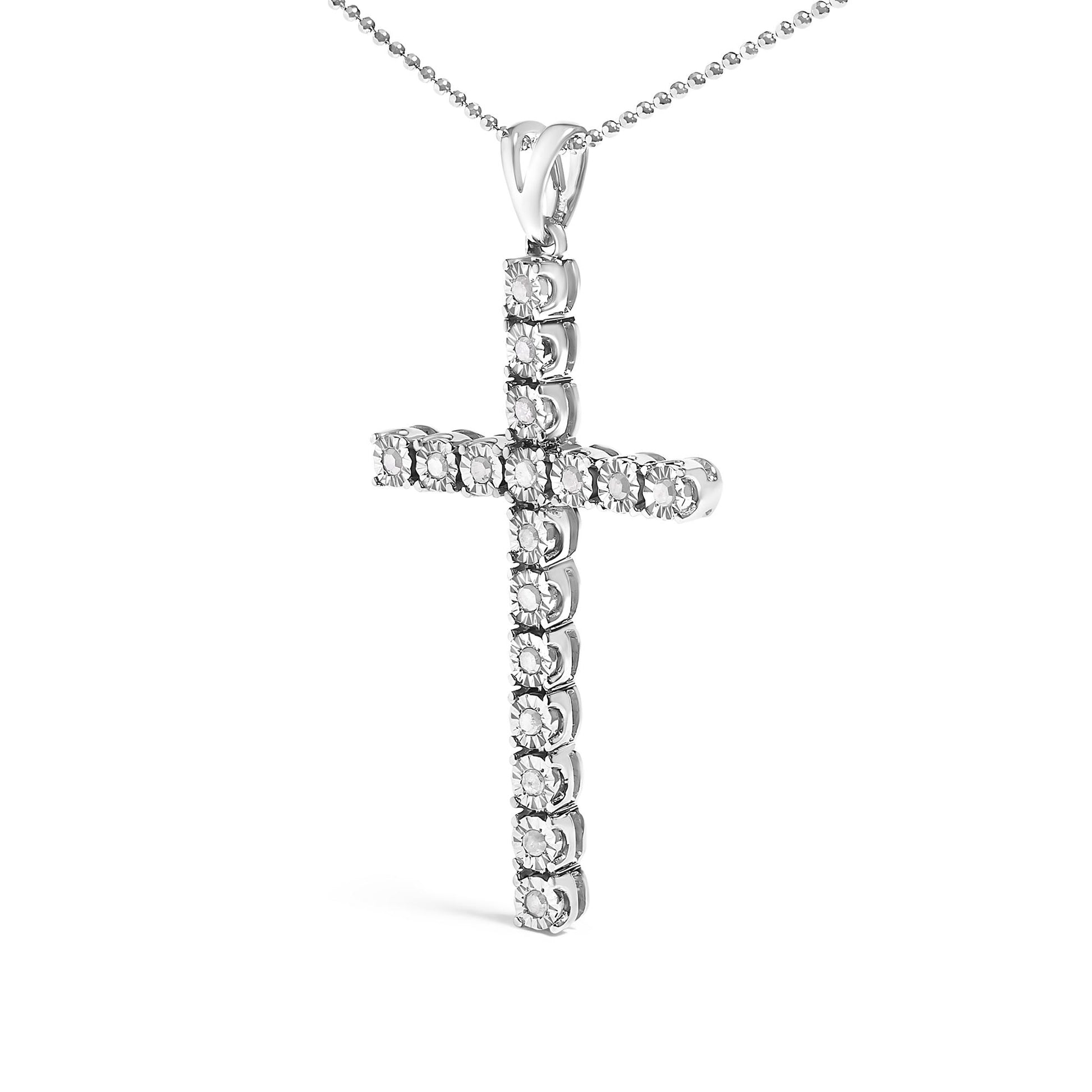 Front angled view of a white metal cross necklace pendant adorned with round white gemstones in a miracle setting, hanging from a beaded chain.