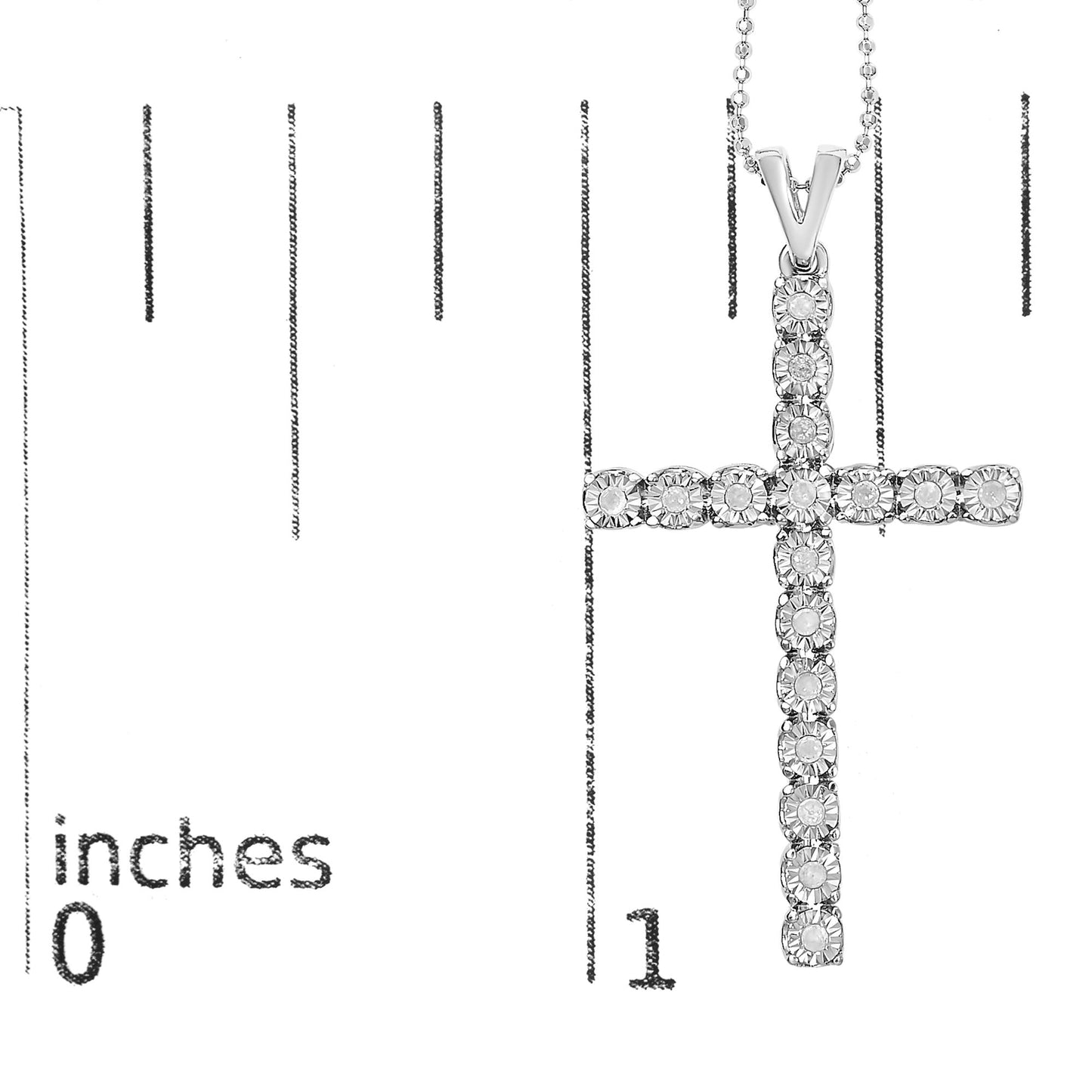 Close-up front view of a white metal cross necklace pendant with round white gemstones in a miracle setting, displayed on a ruler for size reference.