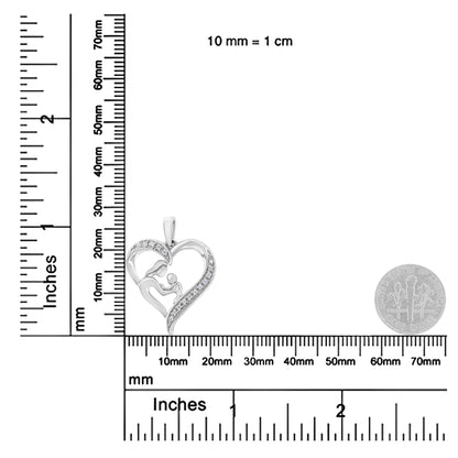 Close-up front angle of a white metal heart-shaped necklace pendant with two human figures inside, accented with round white gemstones in prong settings, placed on a ruler for size reference.