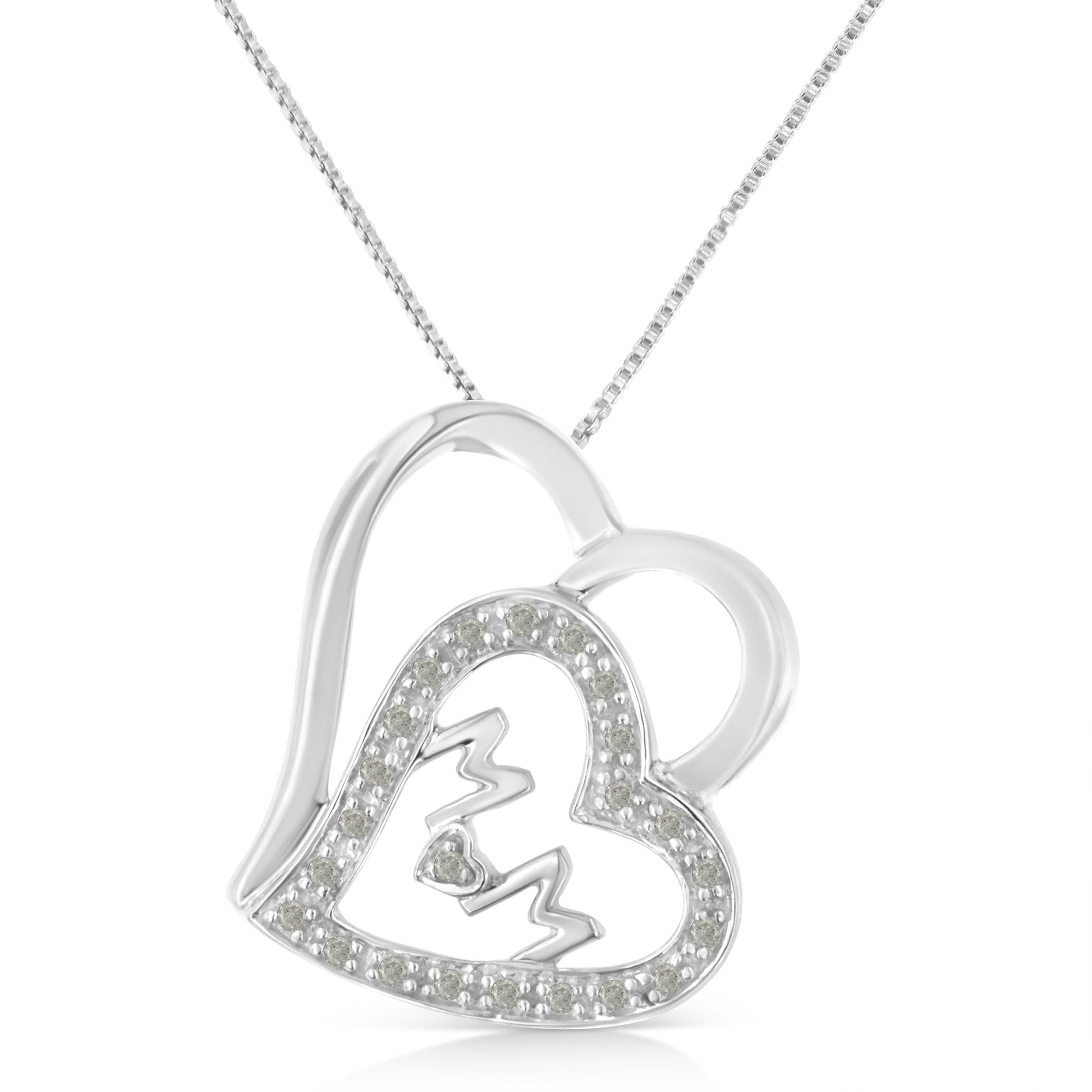 Close-up front angle of a white metal heart-shaped necklace pendant with an open design, featuring a smaller heart outlined with white gemstones and a zigzag detail inside.
