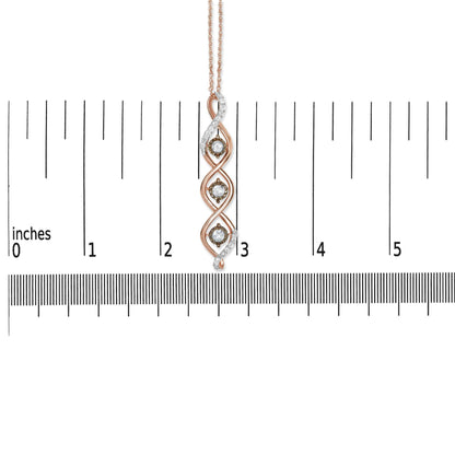 Close-up image of a two-toned necklace pendant with three round white gemstones in prong settings and three round champagne-colored gemstones in miracle settings, displayed vertically on a ruler for size reference.