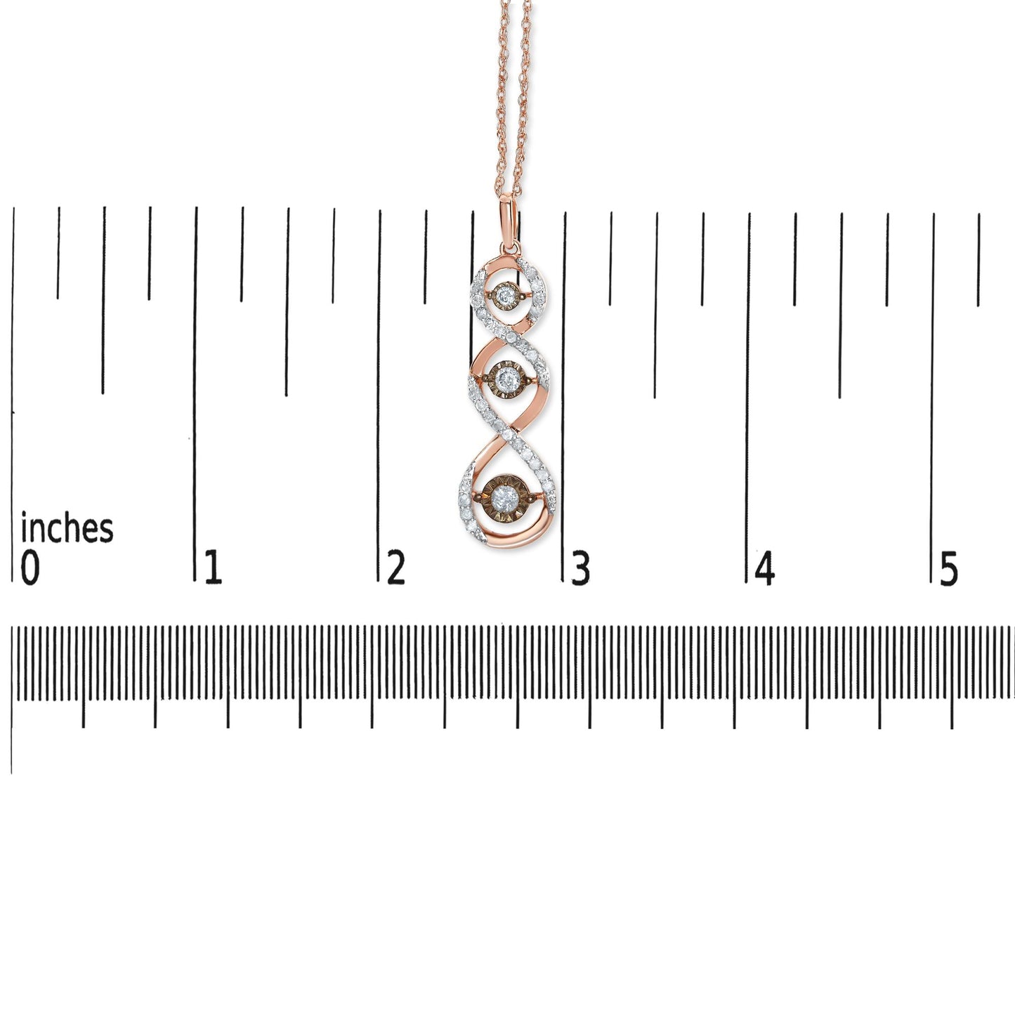 Front view of a two-toned necklace pendant with a twisted design featuring white gemstone accents and three champagne-colored gemstones in a miracle setting, shown on a ruler for size reference.