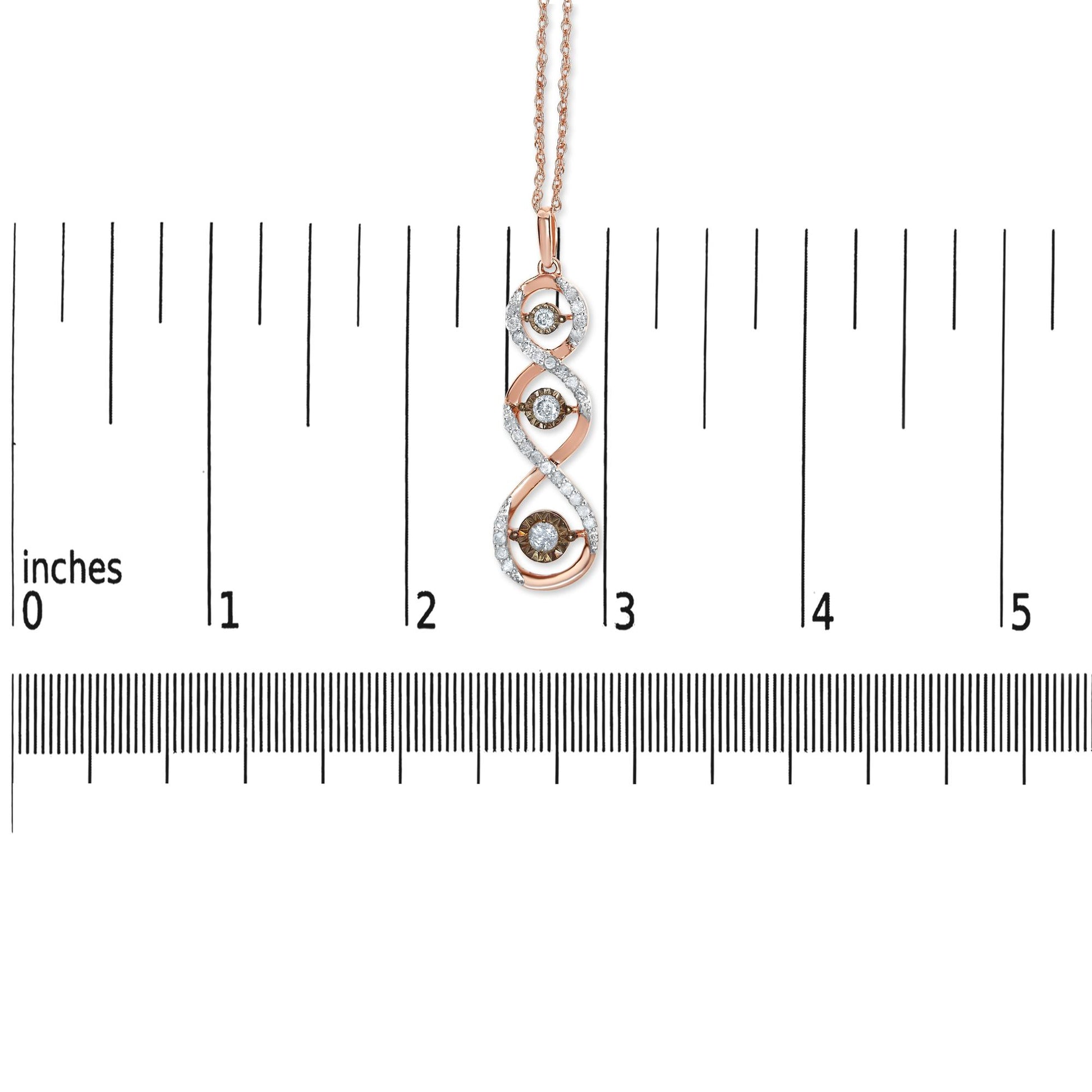 Front view of a two-toned necklace pendant with a twisted design featuring white gemstone accents and three champagne-colored gemstones in a miracle setting, shown on a ruler for size reference.