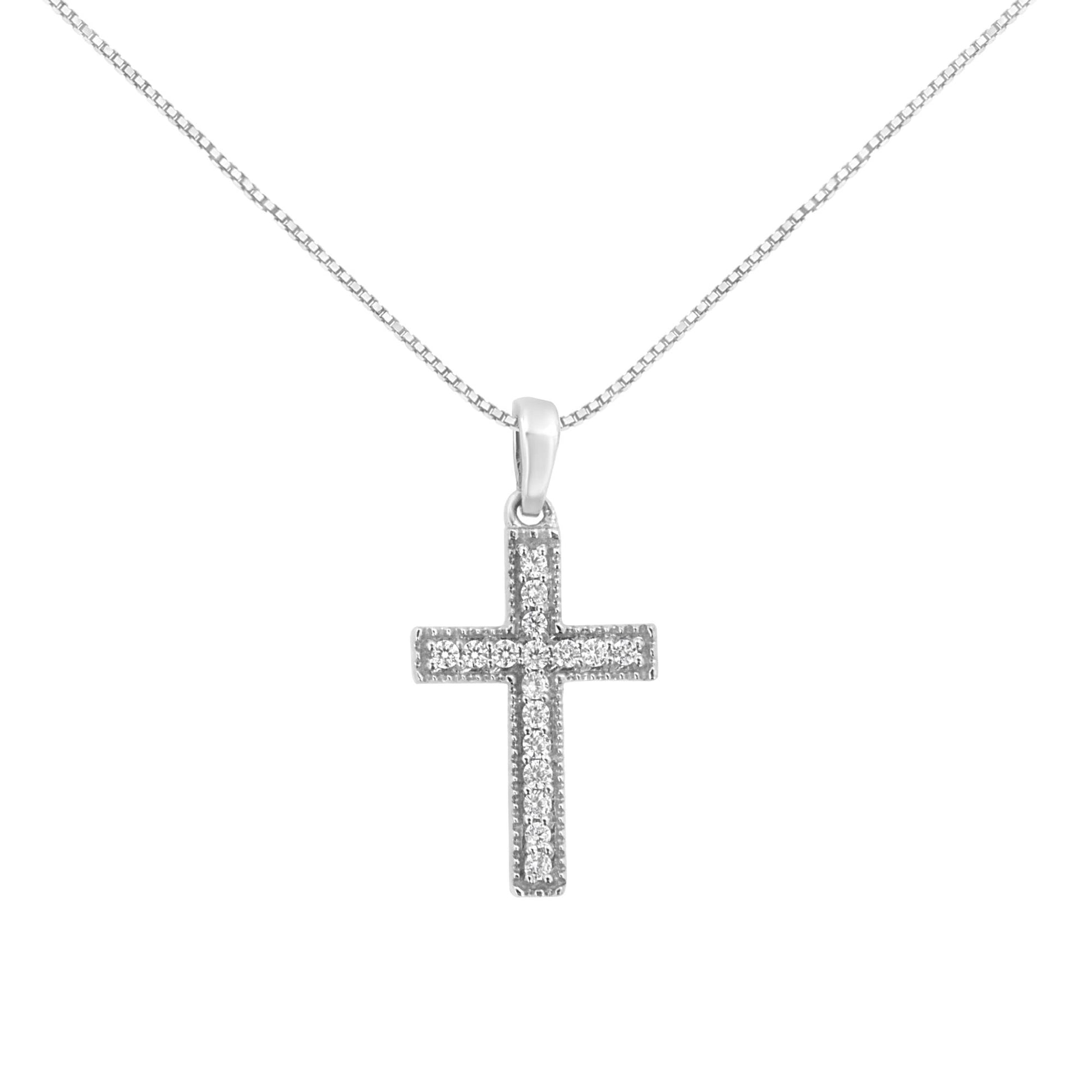 Front-facing view of a white metal cross necklace pendant with round white gemstones set in prongs, hanging from a chain.