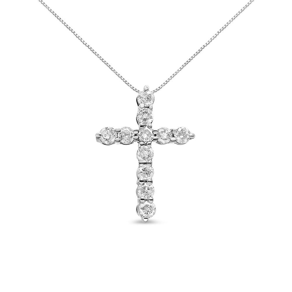 Front-facing angle of a white metal cross-shaped necklace pendant with round white gemstones in prong settings, hanging from a fine chain.