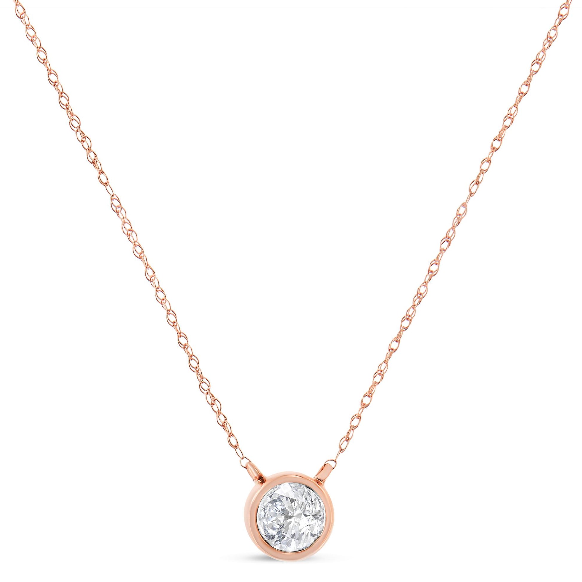Close-up front view of a rose metal necklace with a single round white gemstone in a bezel setting pendant.