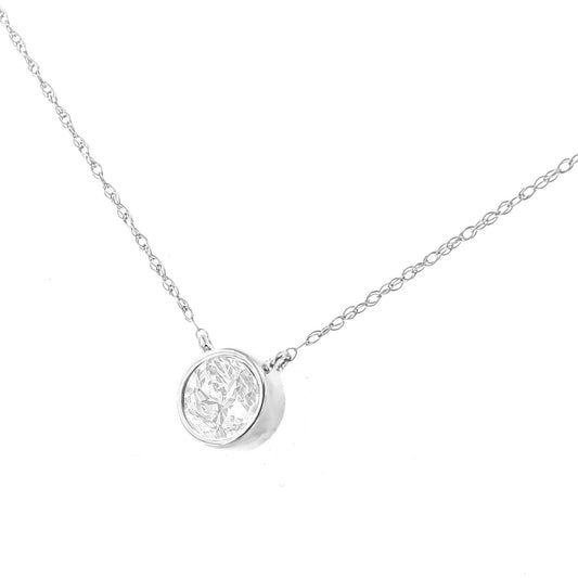 Close-up angled view of a white metal necklace with a round bezel-set white gemstone pendant.
