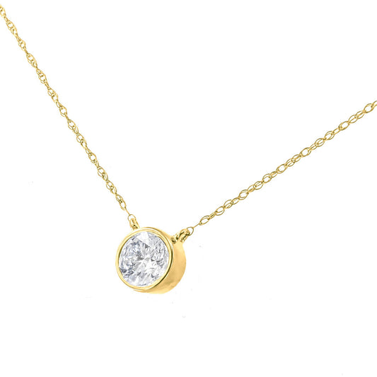 Close-up front angle of a yellow metal necklace with a round white gemstone in a bezel setting pendant.