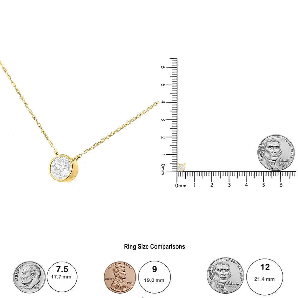 Yellow metal necklace with round white gemstone in bezel setting, shown at an angle with chain extending upwards left, alongside a ruler and coins for size reference.