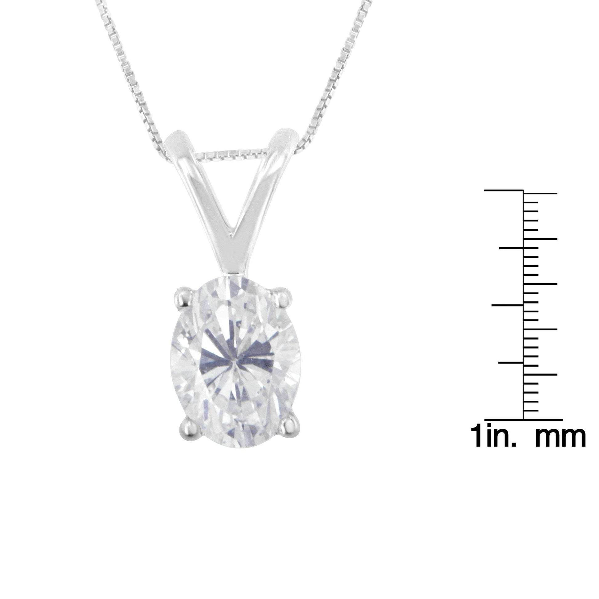Close-up front view of a white metal necklace with an oval-shaped white gemstone in a prong setting, shown next to a ruler for size reference.