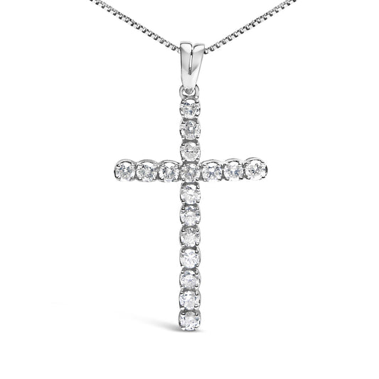 Front-facing shot of a white metal cross necklace pendant with round white gemstones in prong settings.