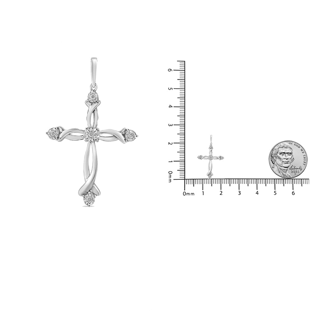 Front view of a white metal cross-shaped necklace pendant with five round white gemstones in a miracle setting, shown next to a ruler and coin for size reference.