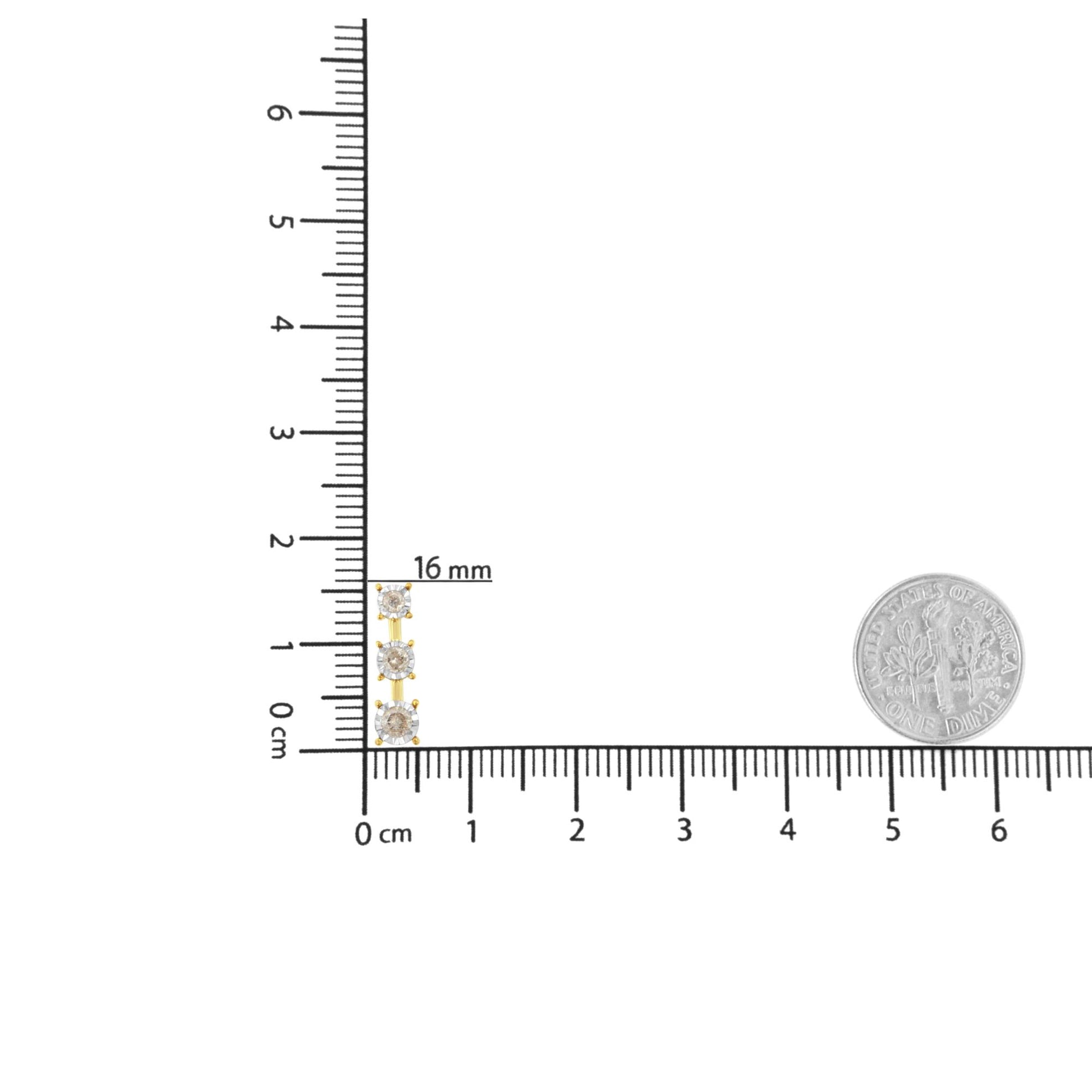 Necklace with three round white gemstones set in yellow and white metal, placed vertically on a ruler and scale for size reference, top-down angle.