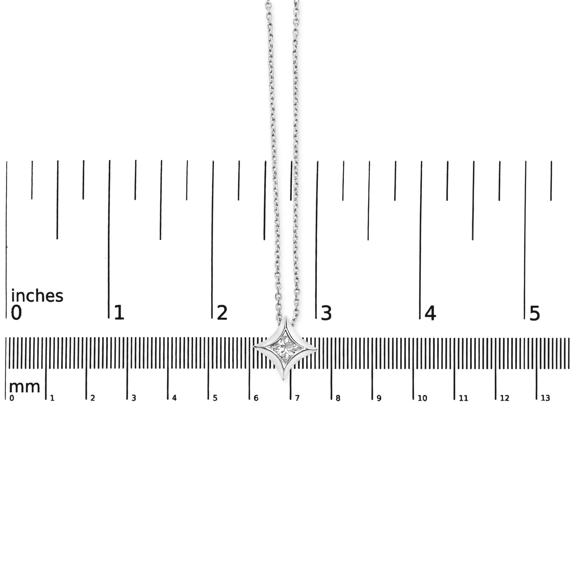 White metal necklace with a princess-shaped white gemstone in bezel setting, photographed from above on a ruler for size reference.