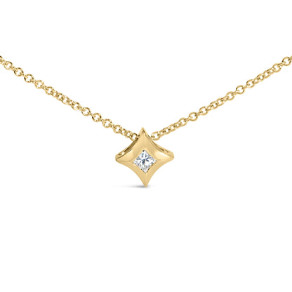 Front-facing shot of a yellow metal necklace with a diamond-shaped pendant featuring a single white gemstone set invisibly in the center.